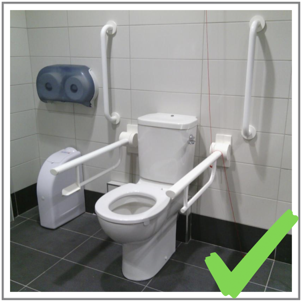 An image of a well arranged accessible toilet commode with all the correct grabe rails.